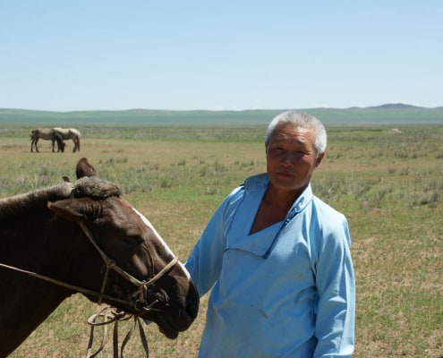 Mongolian cashmere grower with horse